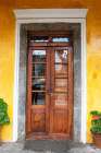 Old wooden doorway with geranium plants at Hacienda San Augustin de Callo in Ecuador. Art Print